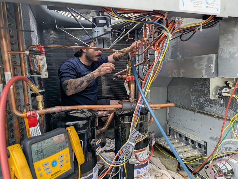 HVAC technician servicing an air conditioning unit outside a home