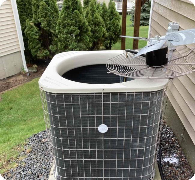 Central air conditioner condenser during a seasonal AC service visit