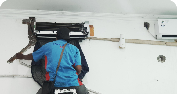 Installers mounting an air conditioning unit on an interior wall