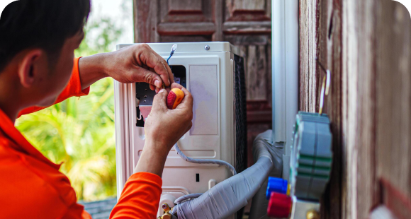 Technician servicing a ductless heat pump outdoor unit