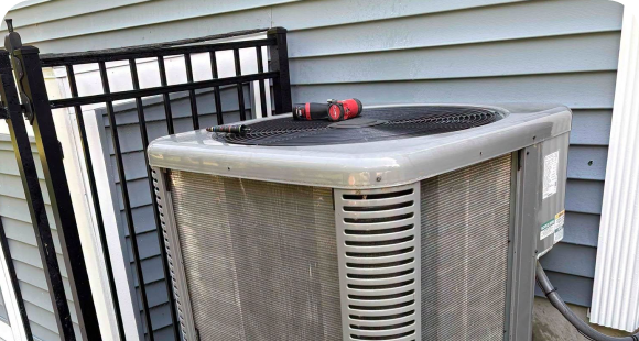 Older central air conditioner receiving a professional inspection