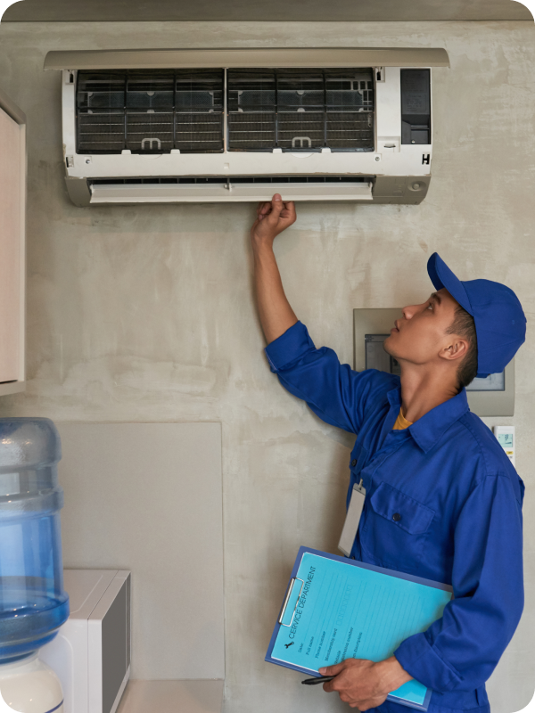 Technician inspecting a wall-mounted AC unit with a service checklist