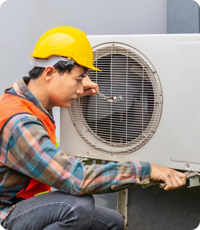 Technician evaluating an air conditioner for replacement