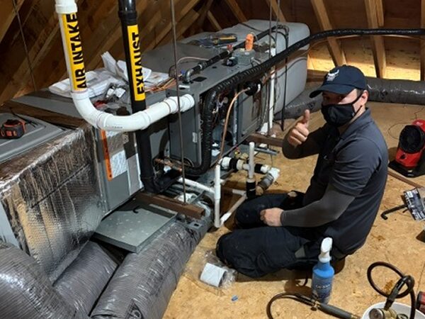 Caron Heating & Cooling technician installing a ducted heat pump air handler