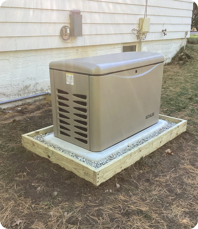 Kohler standby generator installed on a new pad beside a Massachusetts home