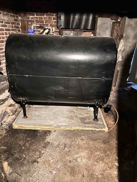 275-gallon heating oil tank on a new pad in a Massachusetts basement, serviced by Caron Heating & Cooling
