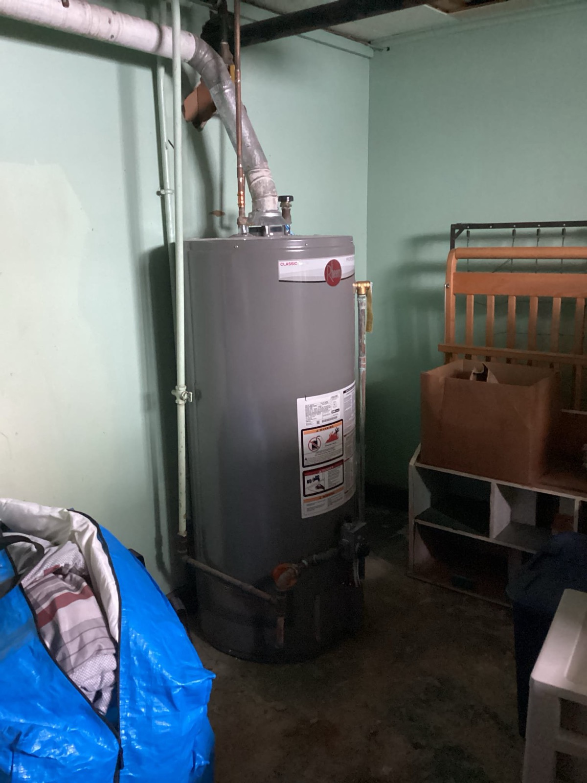 Gas-fired tank water heater installed by Caron Heating & Cooling in a Massachusetts basement