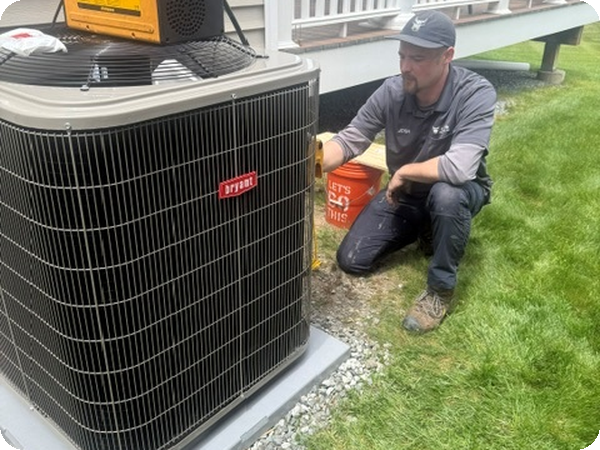 Caron technician servicing a Bryant central air conditioner condenser outside a home