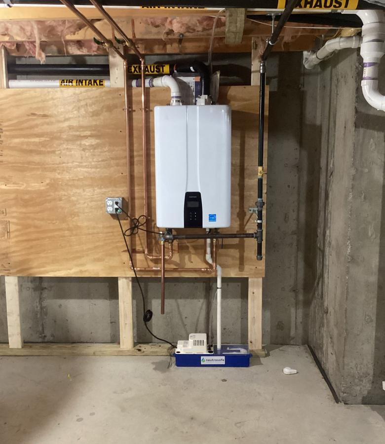 Navien tankless water heater with condensate neutralizer, installed by Caron Heating & Cooling in a Merrimack Valley basement